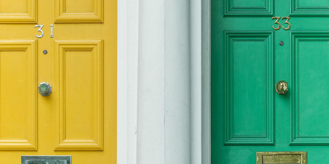 A bright yellow front door to the left of a bright green front door.